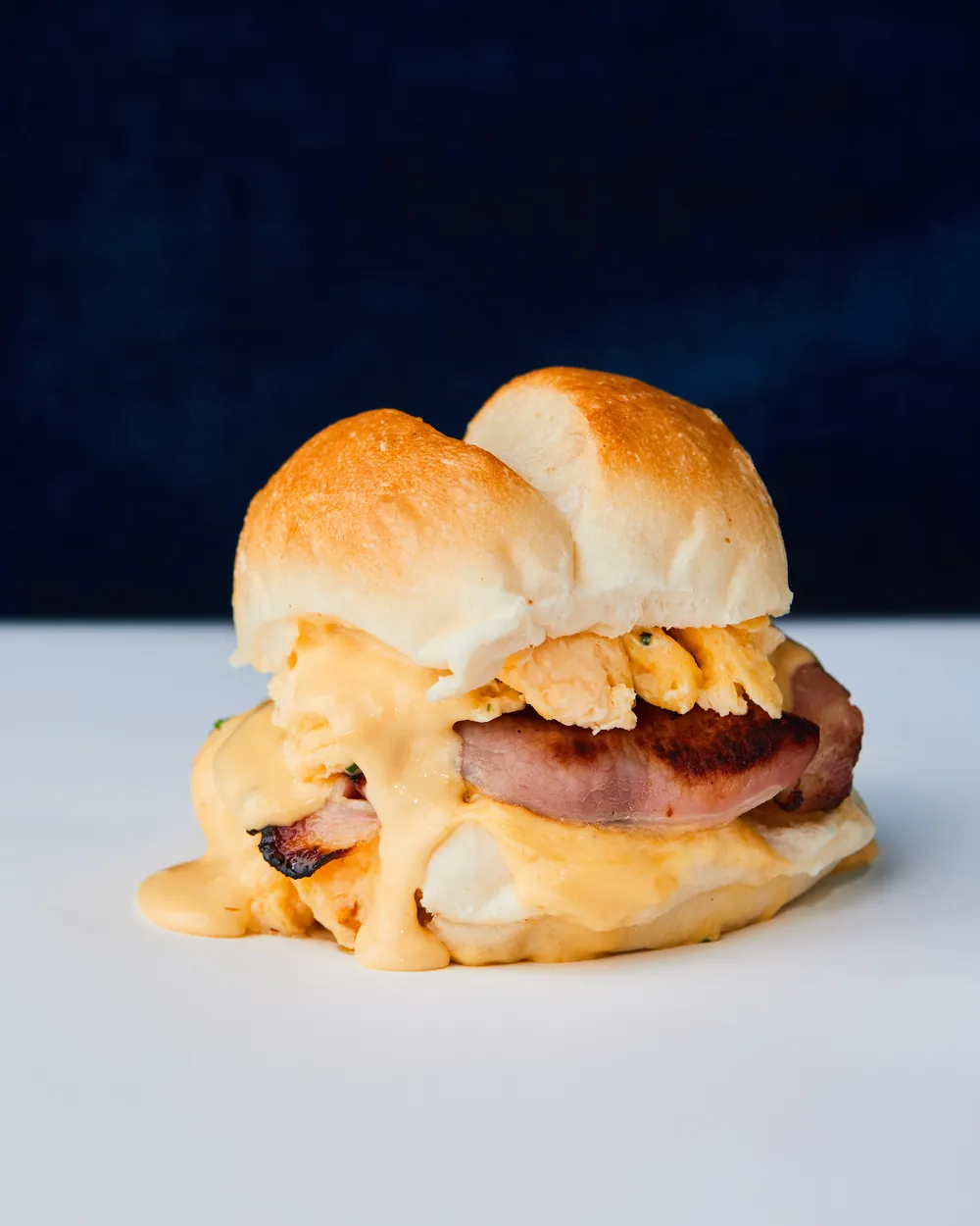 Egg and bacon roll with melted cheese on a soft bun